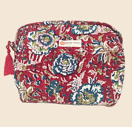 Trousse de toilette XL matelassée rouge From India Boutique, en coton imprimé floral artisanal, avec étiquette cousue et pompon rouge, présentée sur fond beige.
